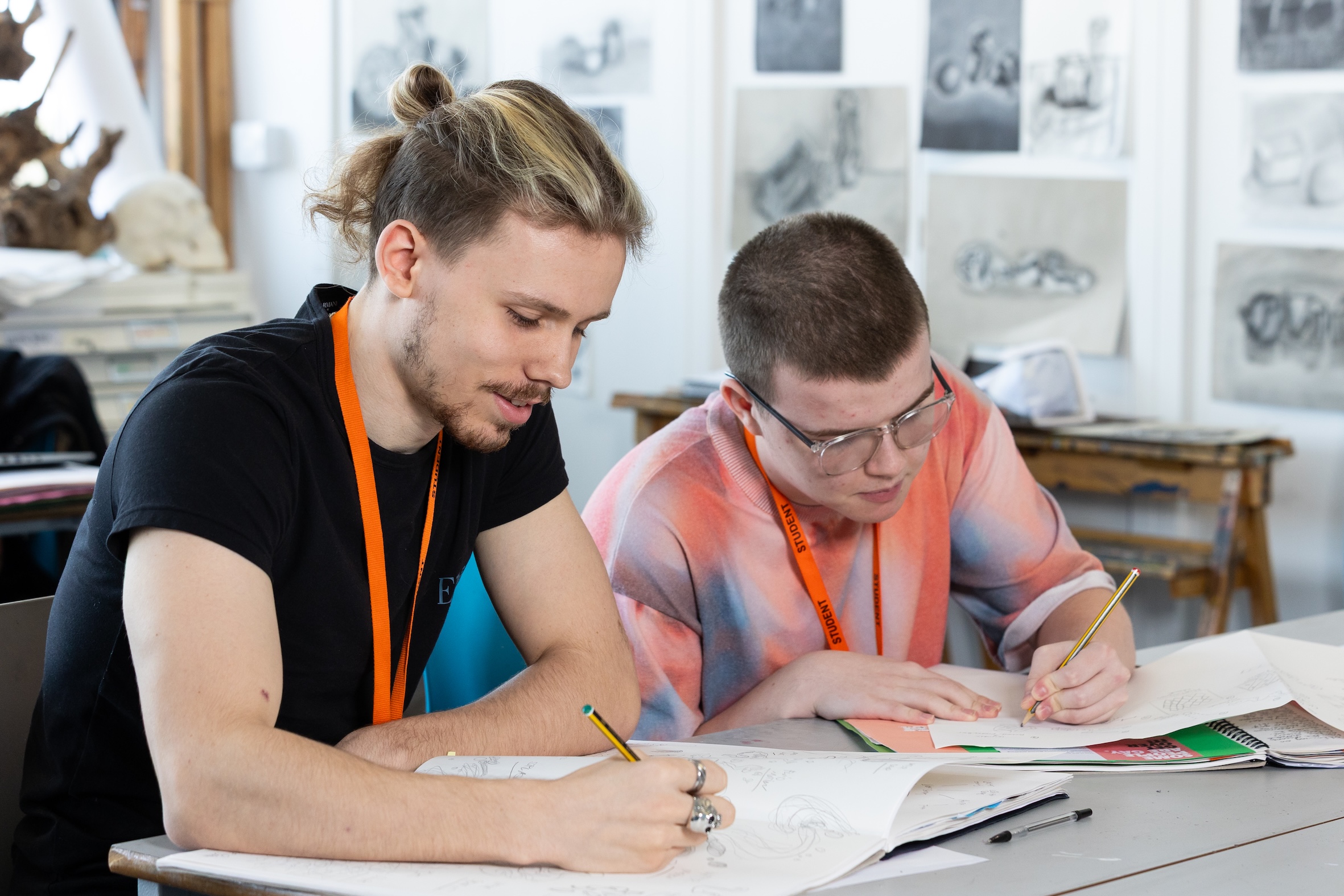 Two male students at North Kent College Tonbridge drawing at desk