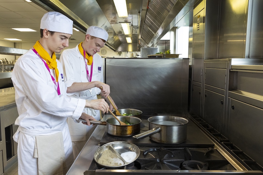 Two student chefs prepare a meal in a professional kitchen at NKC Tonbridge College