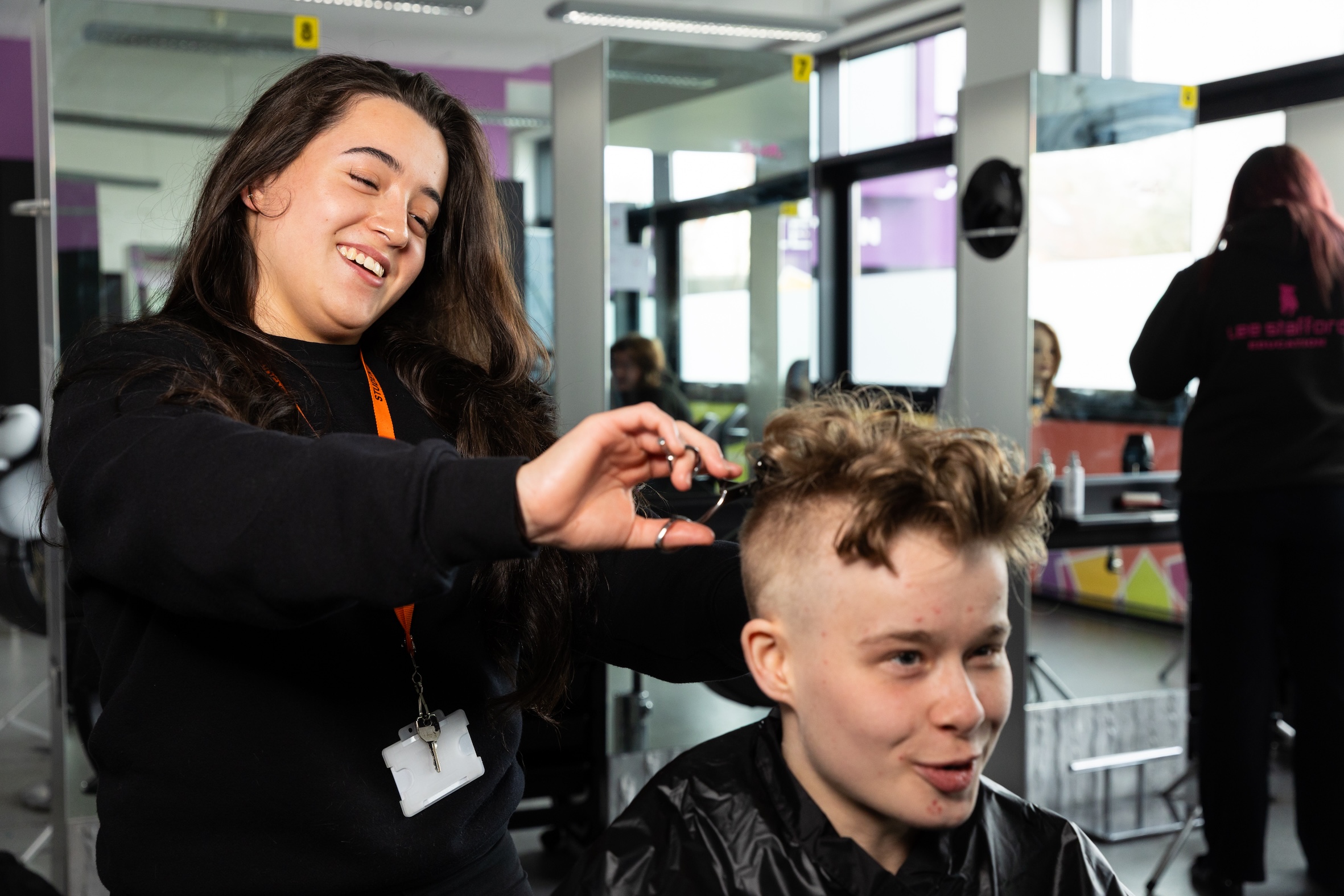 Male having hair cut by female student