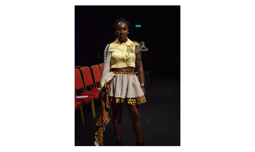 A fashion student strikes a pose on the runway
